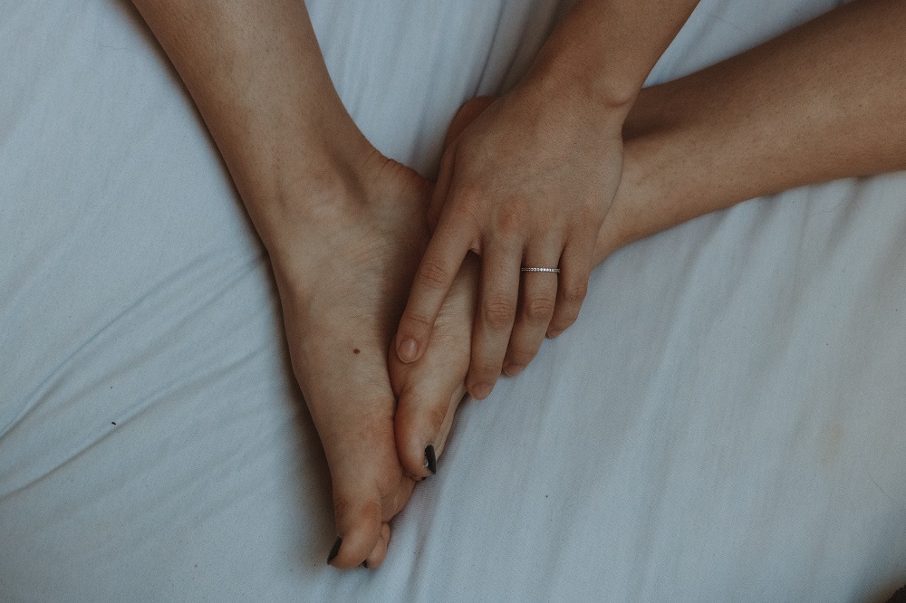 Woman touching her bare feet