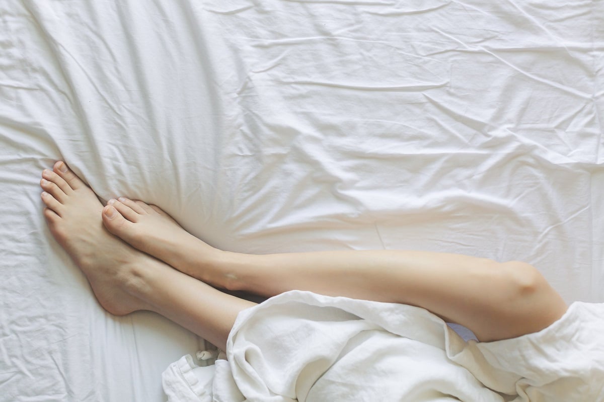 Woman's legs on white sheets