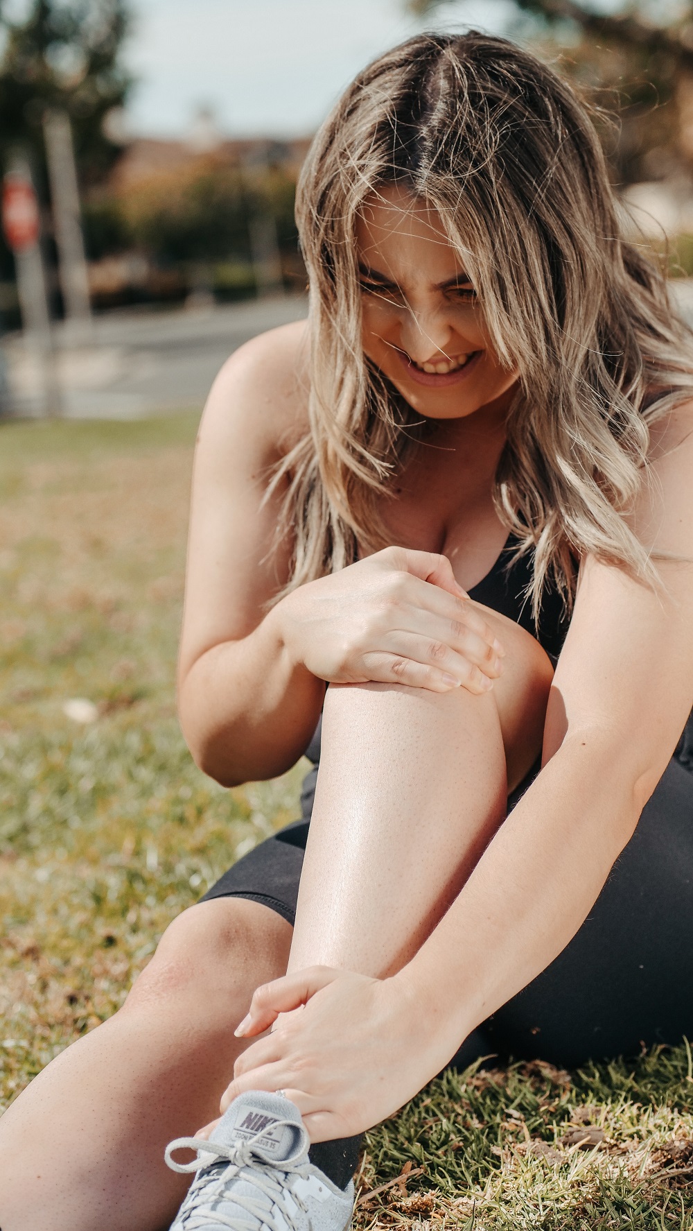 Woman after running, holding her paiful ankle