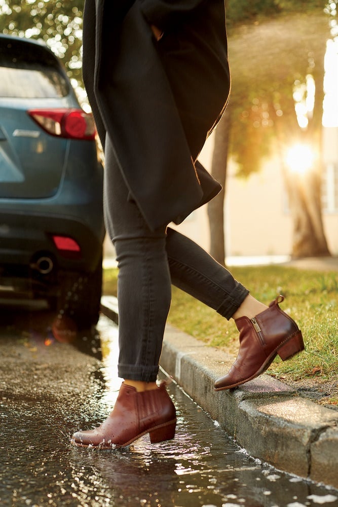 Woman walkin over puddle in waterproof leather booties