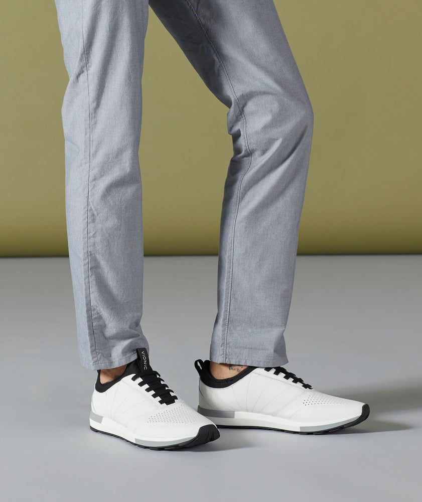 Women's legs on white walking shoes