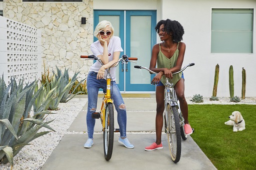 Two woman wearing sneakers ready to go for a bike ride