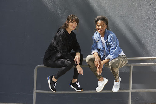 Two young women in sporty outfits with sneakers