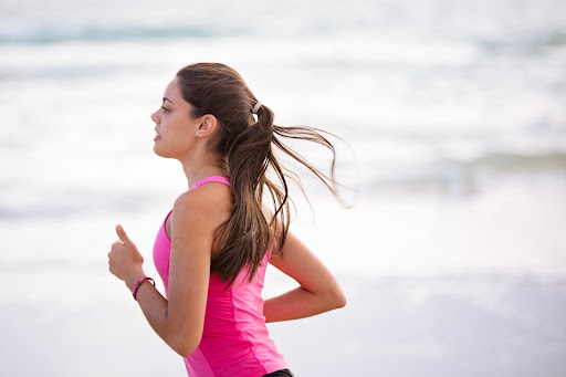 Young wiman in pink sport top jogging
