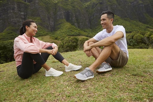 Young pair sitting on the grass diring hiking trip