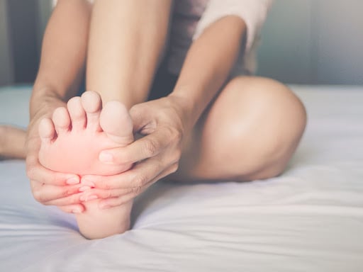 person holding their feet from pain